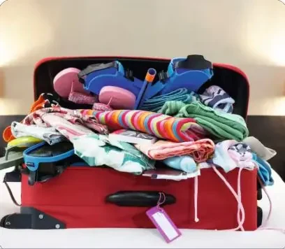 An overpacked, disorganized open suitcase