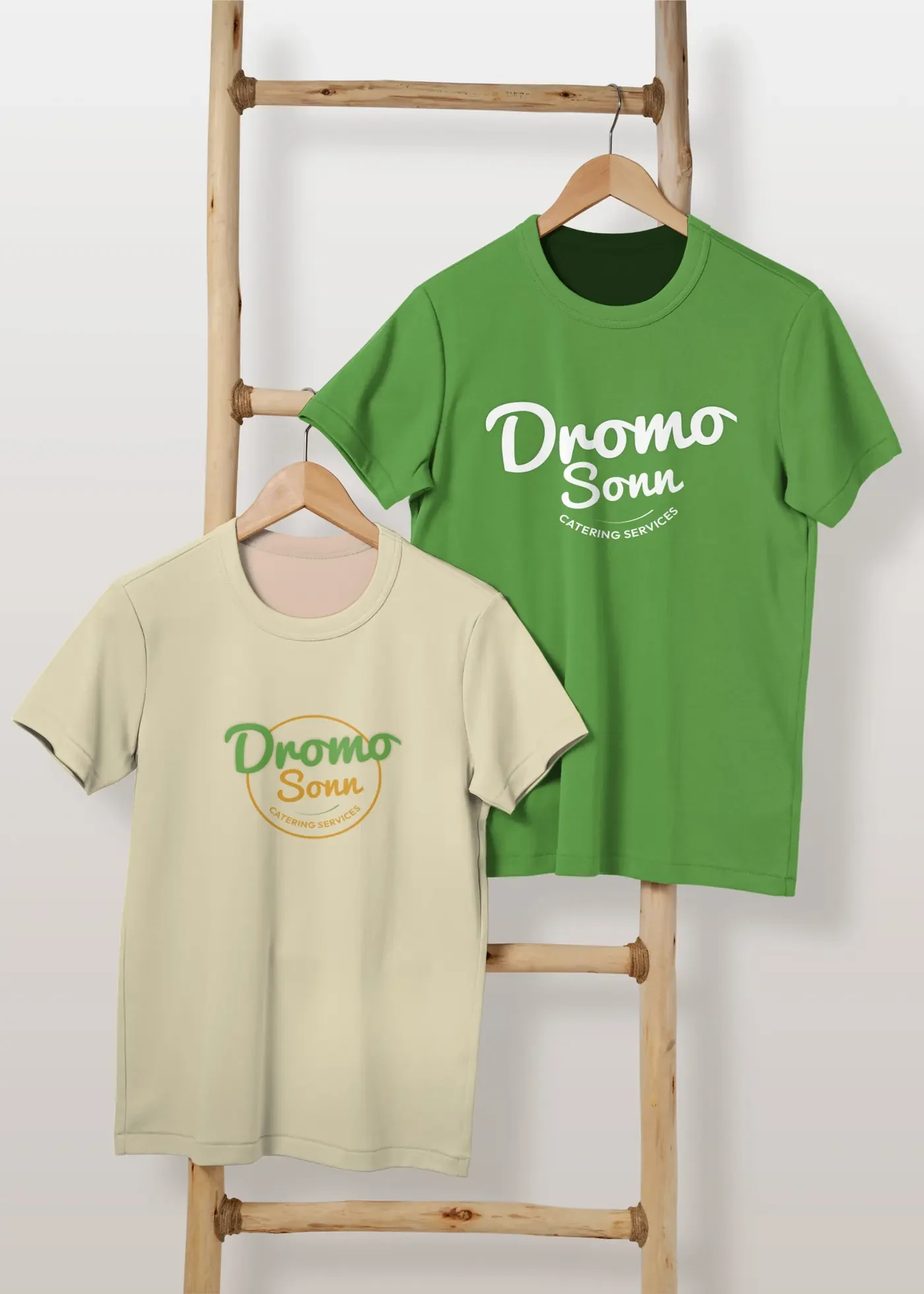 Green and cream Dromo Sonn t-shirts hanging on a wooden ladder